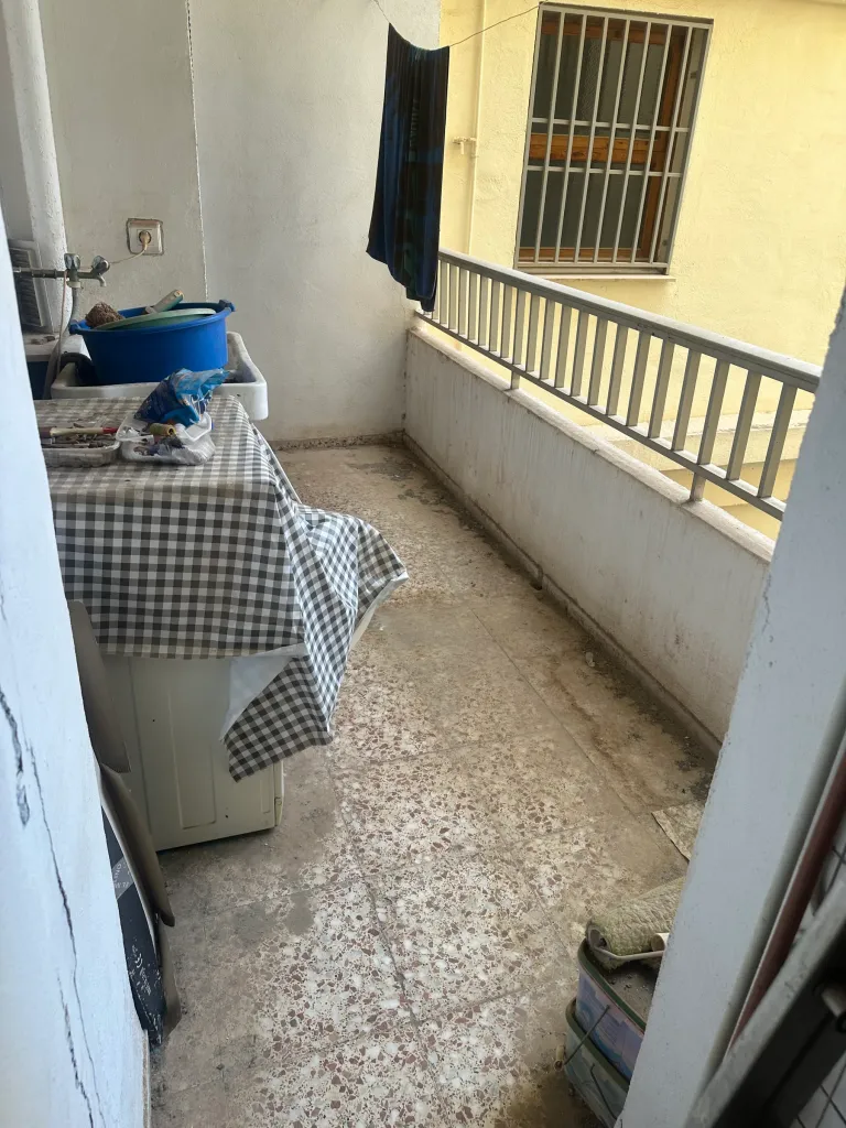 Terraza de un piso con objetos acumulados y el suelo sucio