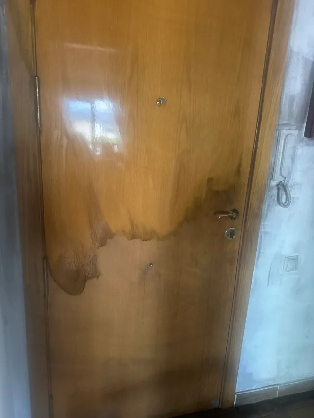 Puerta con hollín de un incendio, mitad limpia y mitad sin limpiar