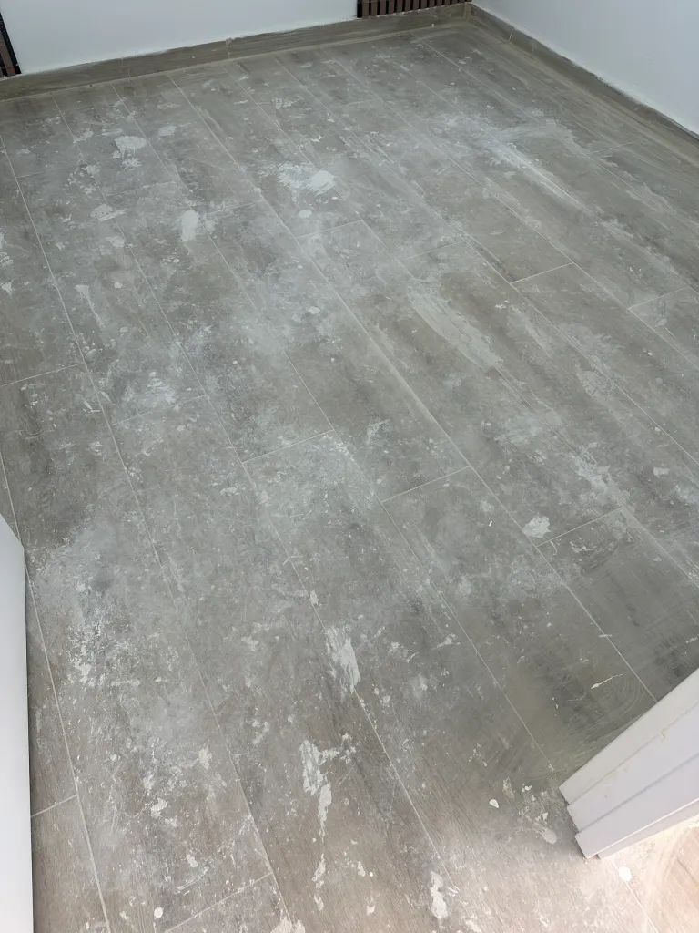 Suelo de tarima con restos de pintura y polvo de obra